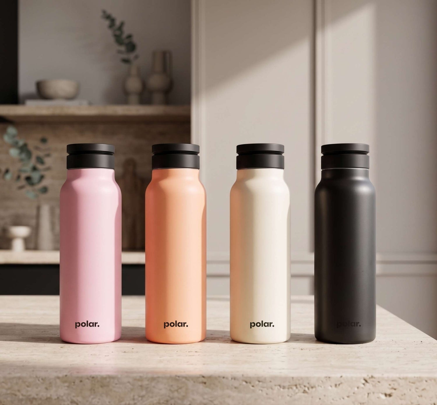 Polar magnetic water bottle with phone holder range in Bloom, Sundust, Sand and Carbon finishes on kitchen bench