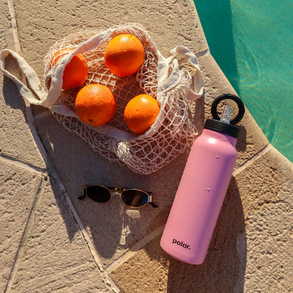 Pink magnetic water bottle with phone holder used as a tripod for filming cooking content and recipes