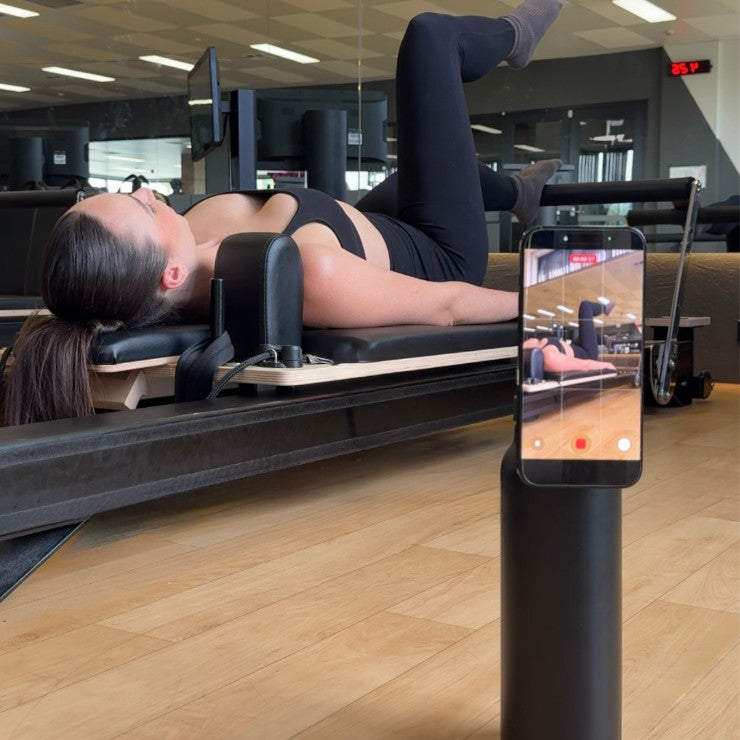 Carbon magnetic water bottle phone holder used as a tripod for recording workouts and training form